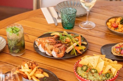 Miniature Location salle Saint-Laurent-du-Var (Alpes-Maritimes) - Playamesa #14 Chambre d'hôtel lumineuse avec lit double, bureau, fauteuil, grandes fenêtres et vue sur un balcon.