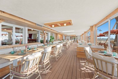 Miniature Location salle Saint-Laurent-du-Var (Alpes-Maritimes) - Playamesa #11 Balcon avec table et chaises blanches, vue sur des palmiers, la mer et un ciel bleu, sous un toit en panneaux blancs.