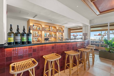 Miniature Location salle Saint-Laurent-du-Var (Alpes-Maritimes) - Playamesa #9 Balcon avec table et chaises blanches, vue sur des palmiers, la mer et un ciel bleu, sous un toit en panneaux blancs.