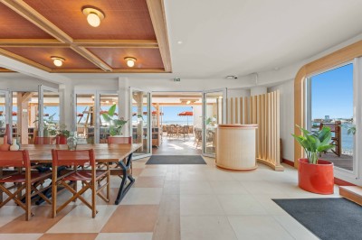 Miniature Location salle Saint-Laurent-du-Var (Alpes-Maritimes) - Playamesa #4 Balcon avec table et chaises blanches, vue sur des palmiers, la mer et un ciel bleu, sous un toit en panneaux blancs.