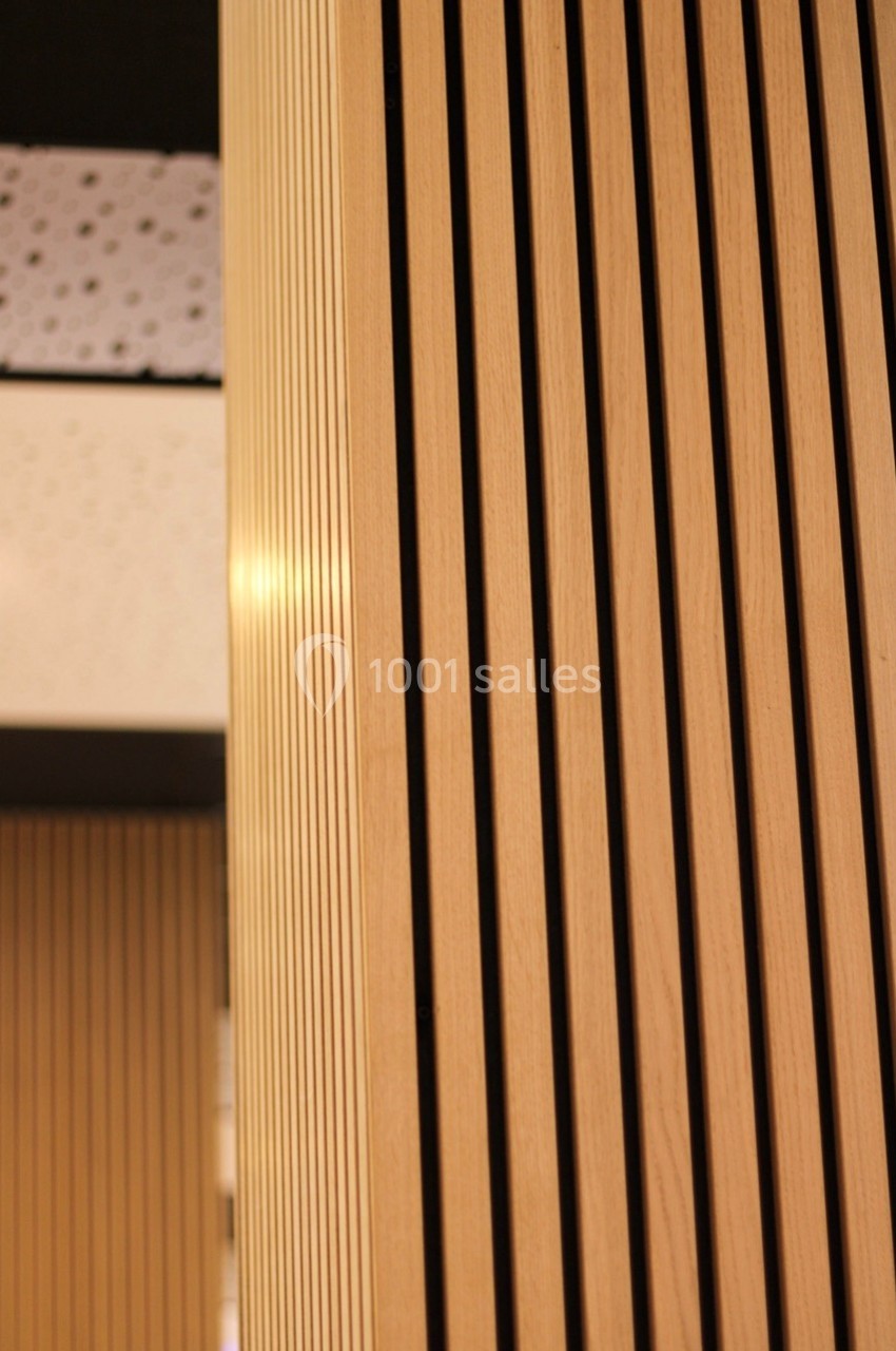 Panneaux en bois clair avec des rainures verticales, intégrés dans un espace intérieur moderne.