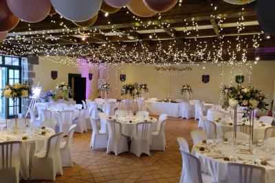 Champ de lotus en fleurs avec des feuilles vertes, des bourgeons et un étang en arrière-plan, entouré d'arbres.