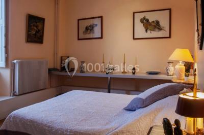 Champ de lotus en fleurs avec des feuilles vertes, des bourgeons et un étang en arrière-plan, entouré d'arbres.