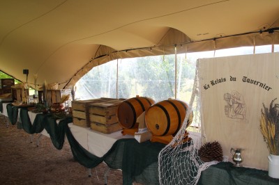 Champ de lotus en fleurs avec des feuilles vertes, des bourgeons et un étang en arrière-plan, entouré d'arbres.