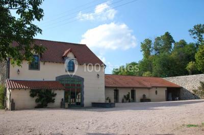 Champ de lotus en fleurs avec des feuilles vertes, des bourgeons et un étang en arrière-plan, entouré d'arbres.