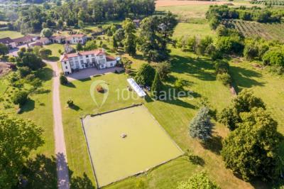 Champ de lotus en fleurs avec des feuilles vertes, des bourgeons et un étang en arrière-plan, entouré d'arbres.