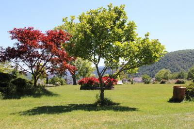 Un groupe de personnes pose devant un tracteur rouge et une machine agricole, devant un grand bâtiment ancien.