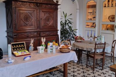Un groupe de personnes pose devant un tracteur rouge et une machine agricole, devant un grand bâtiment ancien.