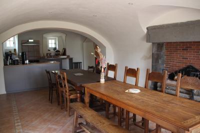 Miniature Groupe d'atelier dans la salle à manger du gîte Un espace extérieur avec une table dressée près d'un étang, des arbres et un groupe de personnes au loin.