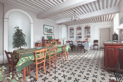 Un groupe de personnes pose devant un tracteur rouge et une machine agricole, devant un grand bâtiment ancien.