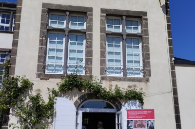 Miniature Le gîte Un espace extérieur avec une table dressée près d'un étang, des arbres et un groupe de personnes au loin.