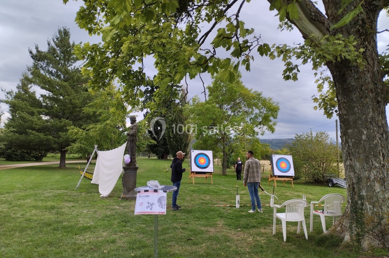 Tir à l'arc Deux personnes discutent près de cibles de tir à l'arc installées dans un parc verdoyant.