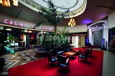 Miniature Location salle Calais (Pas-de-Calais) - Casino de Calais #12 Salle avec un présentoir, des cartons empilés, une table haute décorée et un fond rouge marqué ’50 ans’.