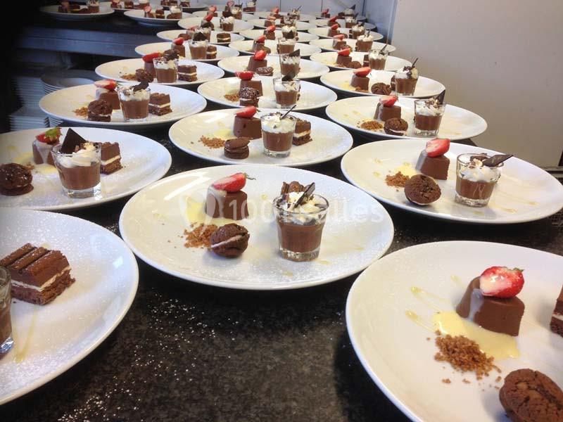 Assiettes dressées avec des desserts variés, incluant mousse au chocolat, fraises, biscuits et crumble.