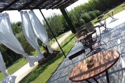 Miniature Location salle Saint-Rémy-de-Provence (Bouches-du-Rhône) - Mas de Jonquerolles #4 Décoration champêtre avec canapé, fauteuils, bottes de paille et guirlandes dans un jardin verdoyant.