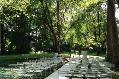 Miniature Location salle Soisy-sur-École (Essonne) - Domaine du Moulin des Noues #21 Disposition de chaises blanches en extérieur autour d'une allée menant à une petite scène sous une tente blanche.