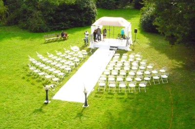 Miniature Location salle Soisy-sur-École (Essonne) - Domaine du Moulin des Noues #27 Disposition de chaises blanches en extérieur autour d'une allée menant à une petite scène sous une tente blanche.