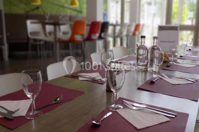 Miniature Location salle Bouray-sur-Juine (Essonne) - Domaine De Frémigny #17 Vue aérienne d'un bâtiment en forme de cour rectangulaire avec des toits en tuiles, entouré de champs et d'arbres.