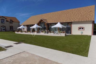 Miniature Location salle Bouray-sur-Juine (Essonne) - Domaine De Frémigny #21 Vue aérienne d'un bâtiment en forme de cour rectangulaire avec des toits en tuiles, entouré de champs et d'arbres.