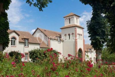 Miniature Location salle Bouray-sur-Juine (Essonne) - Domaine De Frémigny #22 Vue aérienne d'un bâtiment en forme de cour rectangulaire avec des toits en tuiles, entouré de champs et d'arbres.