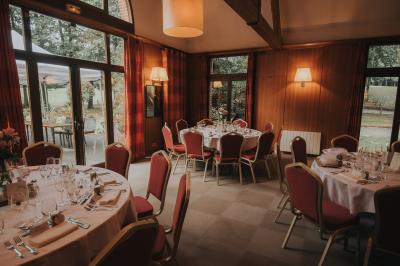 Miniature Location salle Janvry (Essonne) - Golf de Marivaux #5 Maison en bois éclairée la nuit, entourée d'arbres illuminés, sous un ciel nuageux avec la lune visible.