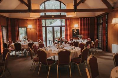 Miniature Location salle Janvry (Essonne) - Golf de Marivaux #3 Maison en bois éclairée la nuit, entourée d'arbres illuminés, sous un ciel nuageux avec la lune visible.