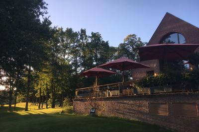 Miniature Location salle Janvry (Essonne) - Golf de Marivaux #28 Maison en bois éclairée la nuit, entourée d'arbres illuminés, sous un ciel nuageux avec la lune visible.
