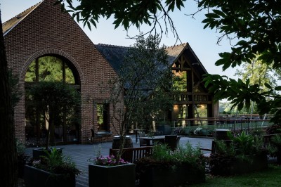 Miniature Location salle Janvry (Essonne) - Golf de Marivaux #2 Maison en bois éclairée la nuit, entourée d'arbres illuminés, sous un ciel nuageux avec la lune visible.