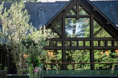 Miniature Location salle Janvry (Essonne) - Golf de Marivaux #3 Maison en bois éclairée la nuit, entourée d'arbres illuminés, sous un ciel nuageux avec la lune visible.