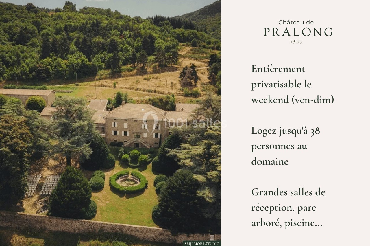 Vue aérienne d'un château entouré de jardins, d'arbres et de collines, avec une cour centrale aménagée.