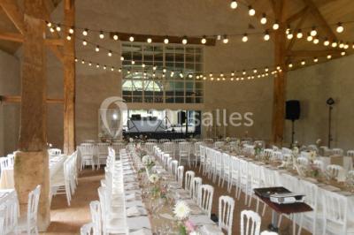 Miniature Location salle Verderonne (Oise) - Domaine de Verderonne #9 Serre illuminée au crépuscule, entourée de murs en pierre et d'arbres, avec une tour en arrière-plan.