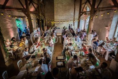 Miniature Location salle Verderonne (Oise) - Domaine de Verderonne #19 Serre illuminée au crépuscule, entourée de murs en pierre et d'arbres, avec une tour en arrière-plan.