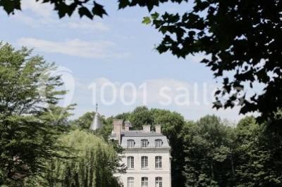 Miniature Location salle Verderonne (Oise) - Domaine de Verderonne #17 Serre illuminée au crépuscule, entourée de murs en pierre et d'arbres, avec une tour en arrière-plan.