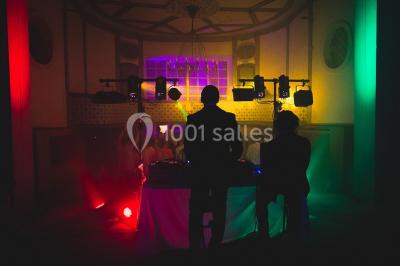 Miniature Location salle Verderonne (Oise) - Domaine de Verderonne #31 Serre illuminée au crépuscule, entourée de murs en pierre et d'arbres, avec une tour en arrière-plan.