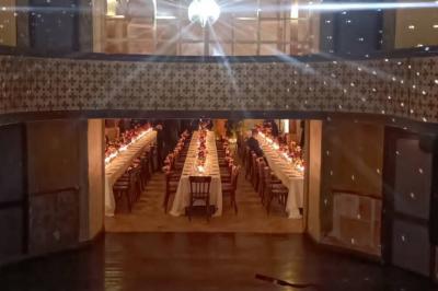 Miniature Location salle Verderonne (Oise) - Domaine de Verderonne #33 Serre illuminée au crépuscule, entourée de murs en pierre et d'arbres, avec une tour en arrière-plan.