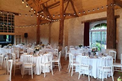 Miniature Location salle Verderonne (Oise) - Domaine de Verderonne #7 Serre illuminée au crépuscule, entourée de murs en pierre et d'arbres, avec une tour en arrière-plan.