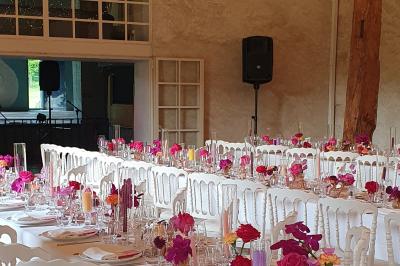 Miniature Location salle Verderonne (Oise) - Domaine de Verderonne #12 Serre illuminée au crépuscule, entourée de murs en pierre et d'arbres, avec une tour en arrière-plan.