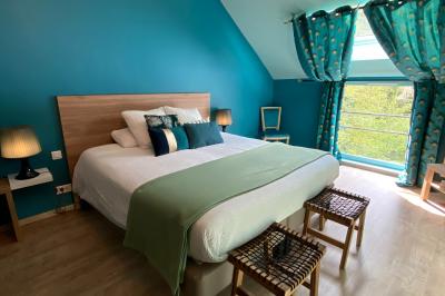 Miniature Chambre, La Gentilhommière  Un vélo ancien posé près de caisses en bois et d'objets décoratifs dans un jardin verdoyant.