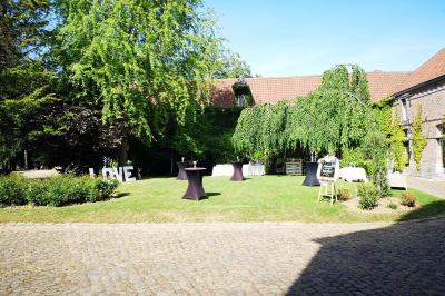 Miniature Jardin, haut du domaine, La Gentilhommière Un vélo ancien posé près de caisses en bois et d'objets décoratifs dans un jardin verdoyant.