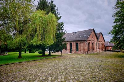 Miniature La Sucrerie, La Gentilhommière  Un vélo ancien posé près de caisses en bois et d'objets décoratifs dans un jardin verdoyant.