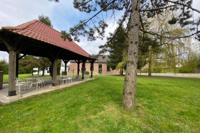 Miniature Le kiosque, bas du domaine, La Gentilhommière Un vélo ancien posé près de caisses en bois et d'objets décoratifs dans un jardin verdoyant.