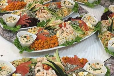 Plateaux de fruits frais composés de bananes, ananas, raisins, fraises, oranges et pastèques, décorés avec des couteaux.