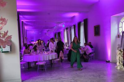 Miniature Location salle Dampierre (Calvados) - Château de Dampierre #8 Château illuminé de nuit avec des murs en pierre, entouré d'arbres et d'une chaîne métallique au premier plan.