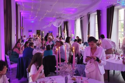 Miniature Location salle Dampierre (Calvados) - Château de Dampierre #9 Château illuminé de nuit avec des murs en pierre, entouré d'arbres et d'une chaîne métallique au premier plan.