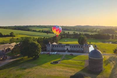 Miniature Location salle Dampierre (Calvados) - Château de Dampierre #1 Château illuminé de nuit avec des murs en pierre, entouré d'arbres et d'une chaîne métallique au premier plan.
