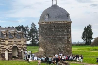 Miniature Location salle Dampierre (Calvados) - Château de Dampierre #35 Château illuminé de nuit avec des murs en pierre, entouré d'arbres et d'une chaîne métallique au premier plan.