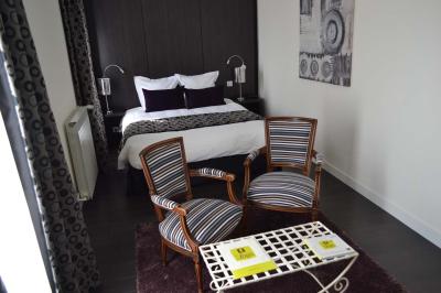 Miniature Location salle Cloyes-les-Trois-Rivières (Eure-et-Loir) - Le Saint Jacques #7 Chambre avec lit double, deux fauteuils rayés, table basse blanche et décoration murale dans un intérieur moderne.