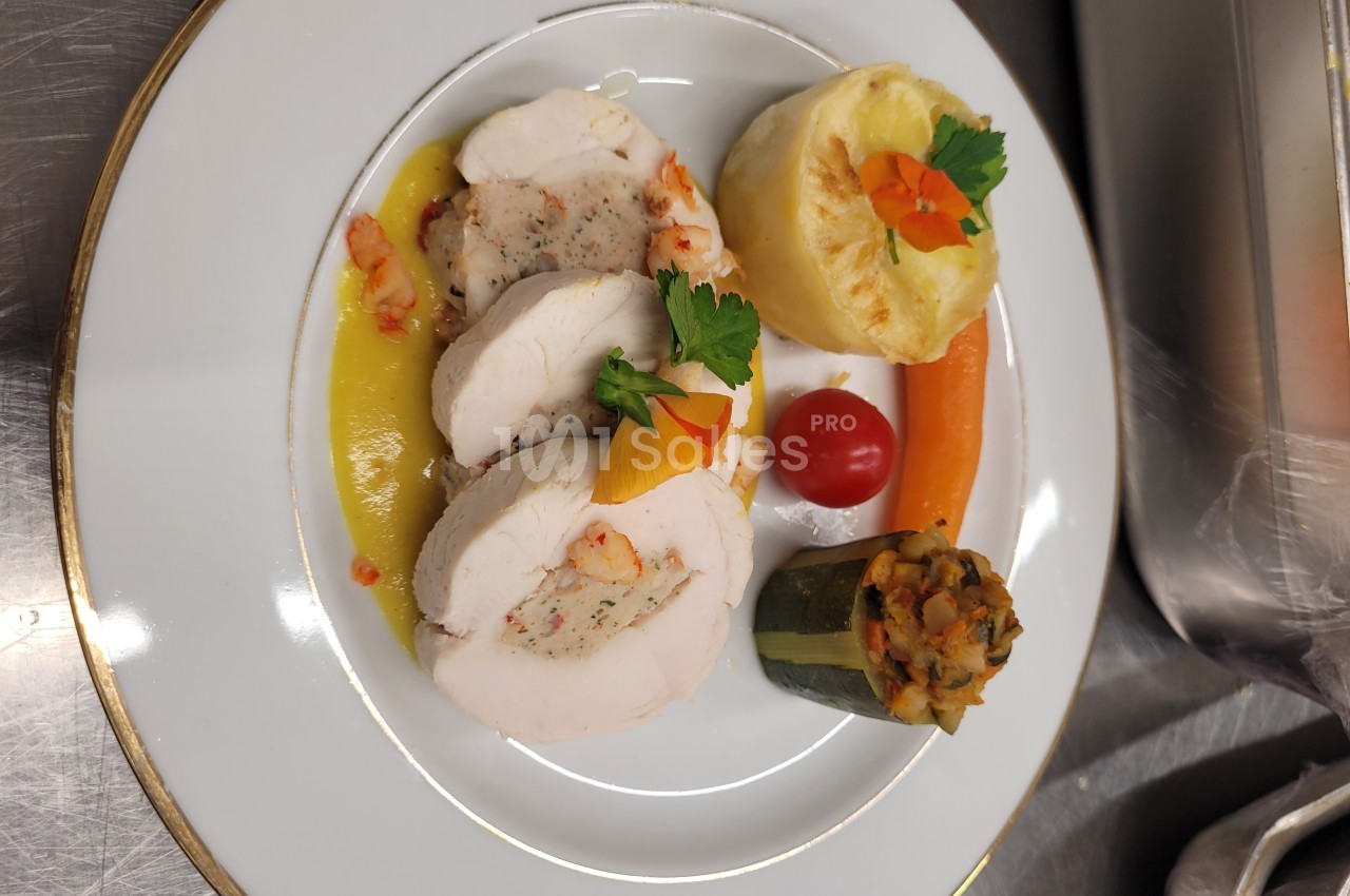 Assiette gastronomique avec roulé de volaille, garnitures de légumes, purée gratinée et sauce dressée.