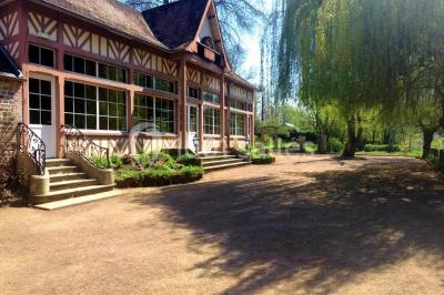 Salle de bain moderne avec carrelage gris, lavabo, toilettes et fenêtre laissant entrer la lumière naturelle.
