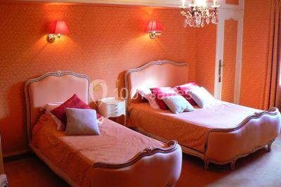 Salle de bain moderne avec carrelage gris, lavabo, toilettes et fenêtre laissant entrer la lumière naturelle.